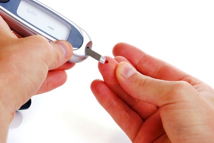 Diabetic is doing a glucose level finger blood test