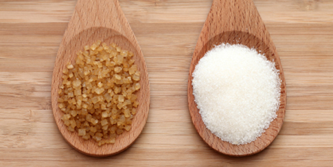 White and brown sugar in a wooden spoons